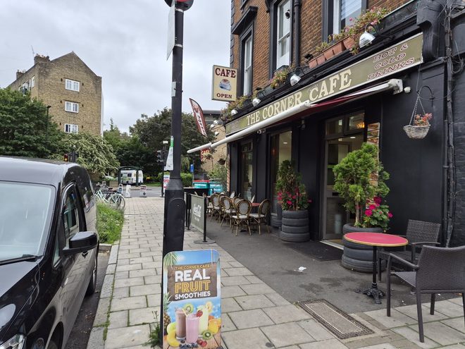 The café's black frontage with hanging plants and outdoor seating